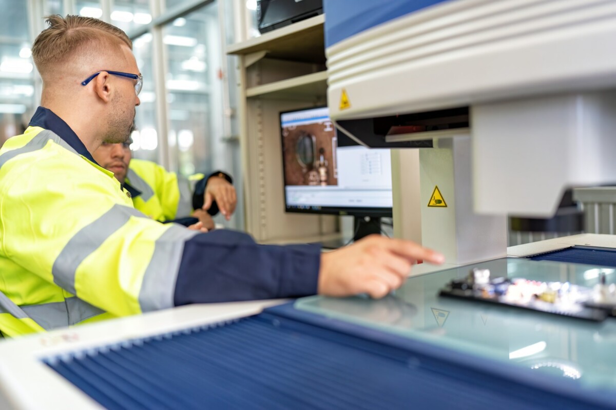 Engineer sitting in robot fabrication room use measuring microscope machine check electronic board